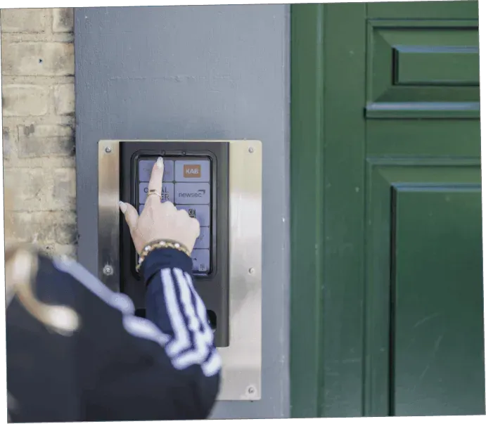 Beboer bruger WelcomeBob touch-dørtelefon ved hovedindgang på Sortedam Dossering